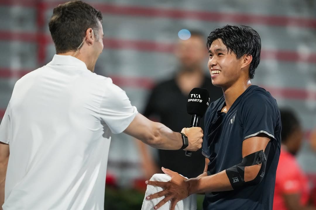 Learner shakes hands with opponent after match, both smiling, broadcast crew visible.